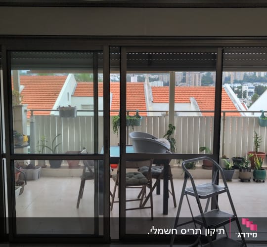 תריסים במרפסת עם נוף עירוני וצמחייה